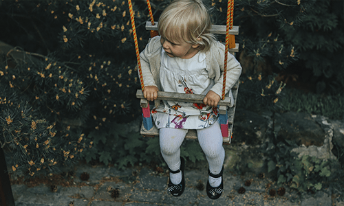 niña jugando en el columpio